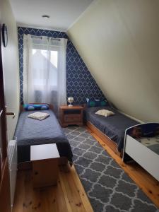- une chambre avec 2 lits et une fenêtre dans l'établissement Dom Niebieski nad jeziorem Orzyskim, à Skomack Wielki
