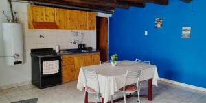 a kitchen with a table with chairs and a blue wall at Depto AGUSTIN in Malargüe