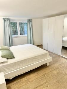 a bedroom with a large white bed and two windows at Ginepro in Tirrenia
