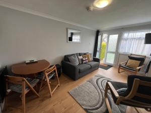 a living room with a couch and a table at 194, Belle Aire, Hemsby - Two bed recently renovated chalet, sleeps 4, pet friendly, free Wi-Fi and bed linen and towels included in Hemsby