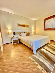een grote slaapkamer met een groot bed en een tafel bij 102 · Apto no batel c/ Ar condicionado in Curitiba