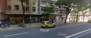 a small yellow car driving down a city street at Apartamento Copacabana Praia, Metrô e Wi-fi Alta Velocidade in Rio de Janeiro