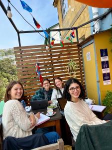 a group of women sitting at a table in a restaurant at Meraki Hostel - Cerro Alegre - Valparaíso in Valparaíso