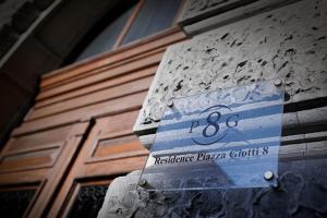 a street sign on the side of a building at Residence Piazza Giotti 8 in Trieste