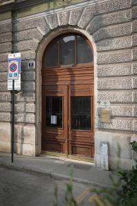 une grande porte en bois sur le côté du bâtiment dans l'établissement Residence Piazza Giotti 8, à Trieste