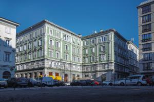 um grande edifício com carros estacionados em frente em Residence Piazza Giotti 8 em Trieste