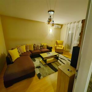 een woonkamer met een bank en een salontafel bij stan na dan centar s in Šabac