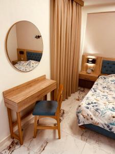 una camera da letto con scrivania, letto e specchio di Marble House a Kavala