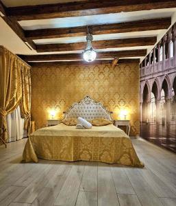 een slaapkamer met een bed met een gouden sprei bij La Residenza di Carlo close to Piazza San marco in Venetië