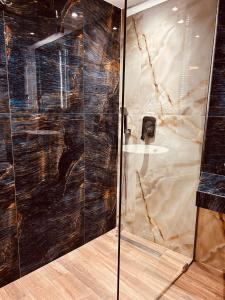 una doccia con una porta in vetro in un bagno di Marble House a Kavala Altre 13 foto