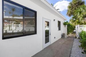 a white house with large windows and a driveway at Mango House en Dania Beach in Dania Beach