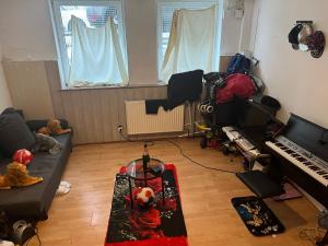 a living room with a couch and a piano at CHEAP SHARED LIVING & BEDROOM IN MULHEIM GERMANY in Mülheim an der Ruhr