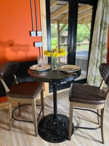 a dining room table with two chairs and a table with flowers on it at Deer View Cabin - Woodland, beaches and Hot tub in Hull