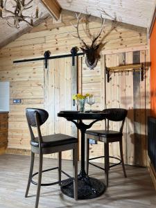 a dining room with a table and two chairs at Deer View Cabin - Woodland, beaches and Hot tub in Hull
