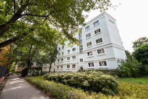 a white building on a street with trees at Nowolipki Chic Studio in Warsaw