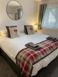 a bedroom with a large bed with a mirror at Kinneuchar Cottage - by Elie, Dog Friendly. in Kilconquhar