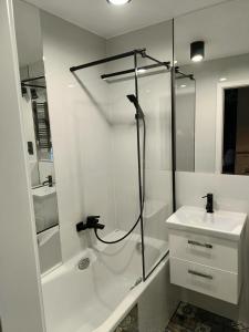 a white bathroom with a shower and a sink at Apartament Chopina 5 m5 - Centrum Sopotu 3 min do Monciaka in Sopot