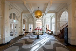 ein großes Zimmer mit einem Tisch mit Blumen darauf in der Unterkunft Pestana Amsterdam Riverside in Amsterdam