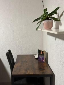 einem Holztisch mit einem Buch und einer Pflanze darauf in der Unterkunft 2 Zimmer Wohnung mit Garten und Terrasse in Bad Hersfeld