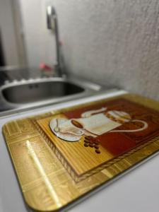un vassoio d'oro seduto su un bancone della cucina con lavandino di 2 Zimmer Wohnung mit Garten und Terrasse a Bad Hersfeld