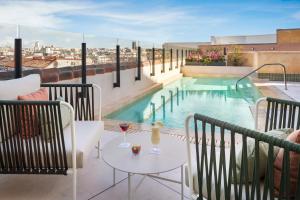 a balcony with a pool and a table with wine glasses at Catalonia Atocha in Madrid