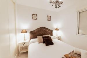 1 dormitorio con 1 cama blanca grande y 2 mesitas de noche en Apto. Plaza Séneca Alicante centro, en Alicante