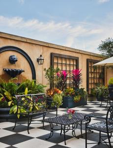 um pátio com mesas, cadeiras e vasos de plantas em French Quarter Inn em Charleston