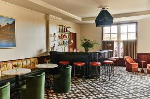 eine Bar mit Hockern und Tischen in einem Restaurant in der Unterkunft French Quarter Inn in Charleston