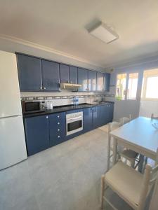 a kitchen with blue cabinets and a table and a table and a tableablish at Beis House in Las Palmas de Gran Canaria