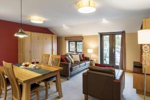 a living room with a table and a couch at Lakeland Apartment At Windermere Marina Village in Bowness-on-Windermere