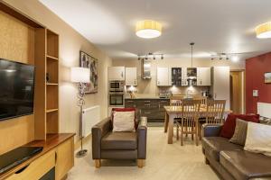 a living room with a couch and a dining room at Lakeland Apartment At Windermere Marina Village in Bowness-on-Windermere