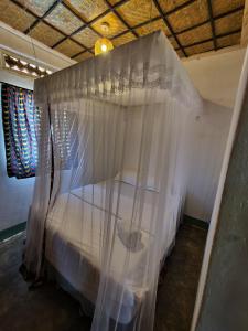Bett mit Baldachin in einem Zimmer in der Unterkunft Rwekishokye Country Club in Mbarara