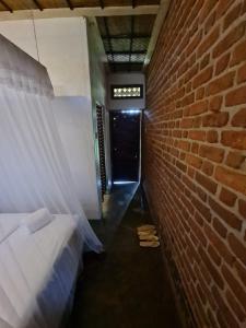 una camera con un muro di mattoni e un letto e una porta di Rwekishokye Country Club a Mbarara