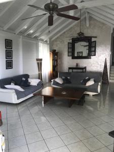 ein Wohnzimmer mit 2 Sofas und einem Couchtisch in der Unterkunft Superbe Villa de vacances aux Trois ilets in Les Trois-Îlets