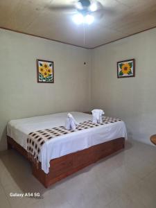una camera da letto con un letto e asciugamani di Alojamiento, Restaurante Chic Paradise a Iquitos