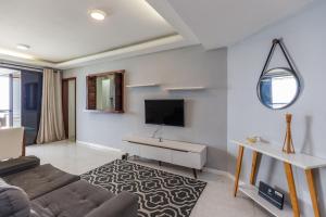 a living room with a couch and a tv at Vista Panoramica da Praia com 2qts, e vaga in Rio de Janeiro
