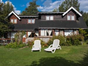 two lawn chairs in front of a house at Cabañas Ruca Nahuel in Villa La Angostura