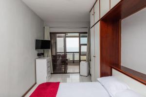 a bedroom with a bed and a view of a balcony at Vista Panoramica da Praia com 2qts, e vaga in Rio de Janeiro