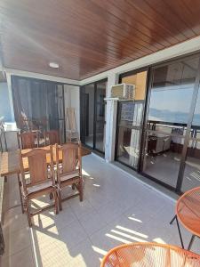 a patio with a table and chairs and a balcony at Vista Panoramica da Praia com 2qts, e vaga in Rio de Janeiro