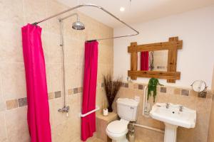 a bathroom with a pink shower curtain and a toilet at Smallicombe Farm in Colyton