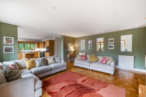 a living room with two couches and a kitchen at Treetops in Wimborne Minster