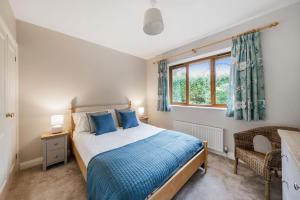 a bedroom with a bed and a window at Treetops in Wimborne Minster