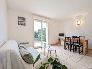 a living room with a couch and a table at Résidence Appart Hotel Au Pitot in Biscarrosse-Plage