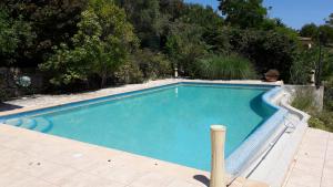 uma piscina azul com um poste ao lado em Appartement Numéro 1 - piscine em Valbonne
