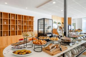 - un buffet avec du pain et d'autres aliments sur une table dans l'établissement B&B HOTEL Cuneo Cristal, à Coni