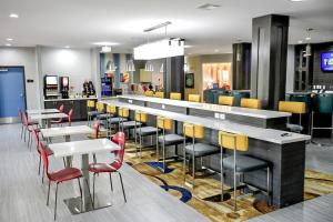ein Restaurant mit einer Bar mit Tischen und Stühlen in der Unterkunft Del-Mar Airport Inn & Suites in Shreveport