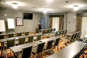 una sala conferenze con tavoli, sedie e un podio di Del-Mar Airport Inn & Suites a Shreveport