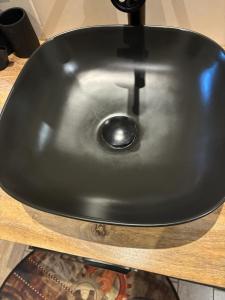 a black sink on top of a wooden table at Chambre d'hôtes "Sur la route des Terrils" in Vendin-le-Vieil