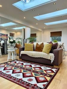 ein Wohnzimmer mit einem Sofa und einem Teppich in der Unterkunft Sunny London Garden Apartment in London