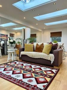 a living room with a couch and a rug at Sunny London Garden Apartment in London